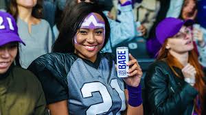 An AB InBev poses with Babe Wine while wearing a football jersey because women deserve to experience alcohol harm too